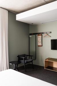 a room with a bed and a chair and a mirror at Alex Hotel in Perth