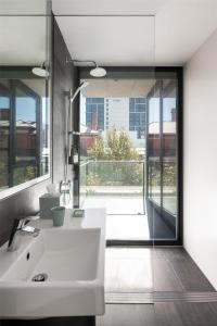 a bathroom with a white sink and a large window at Alex Hotel in Perth