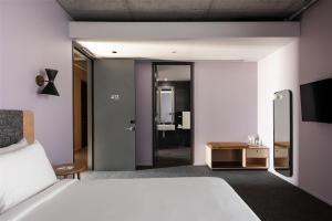 a hotel room with a bed and a bathroom at Alex Hotel in Perth