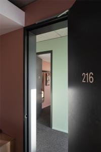 a hallway with an open door with the number at Alex Hotel in Perth