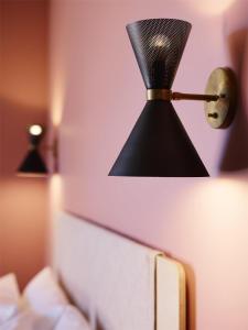a lamp on a wall next to a bed at Alex Hotel in Perth