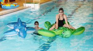two girls in a swimming pool with inflatables at Chutian Guangdong International Hotel in Wuhan