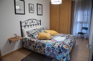 Un dormitorio con una cama, una mesa y una silla. en LA BALLENERA, en Cangas de Morrazo