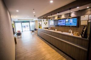 un ristorante con un lungo bancone e un bar di Hanting Hotel Zhangjiajie Tianmen Mountain Zhongshang Plaza a Zhangjiajie