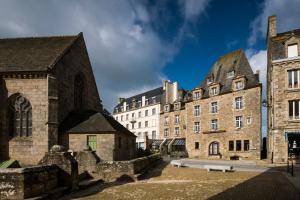 an old stone church and buildings in a city at Hotel Mercure Roscoff Bord De Mer in Roscoff