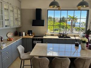 a kitchen with a table with chairs and a large window at New Unique Stone Villa with Seaview, Pool and Garden in Poljane