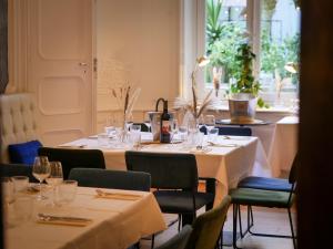 a table in a restaurant with tables and chairs at Hôtel & Suites Maison Montgrand - Vieux Port in Marseille