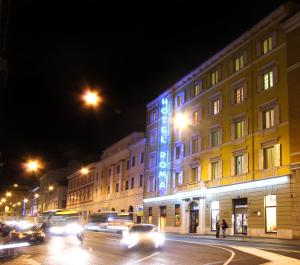 a building with blue lights on the side of it at night at Hotel Roma in Trieste