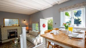a dining room with a table and a fireplace at Honeywick Cottage in Stow on the Wold