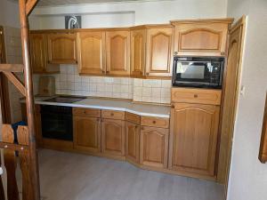 a small kitchen with wooden cabinets and a microwave at Haus I WIFI I Monteur in Sallgast +1 photo