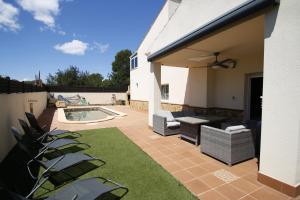 a patio with a table and chairs and a pool at Villa Luka by Parc Mont-roig in Montroig