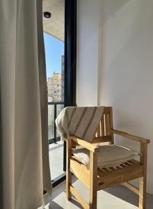 a wooden chair sitting in front of a window at Zona Güemes 2 ambiente N 503 in Mar del Plata