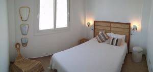 a bedroom with a bed and a window and a chair at Casa Aurora Vejer in Vejer de la Frontera