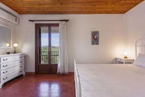 a bedroom with a bed and a door to a balcony at Villa Lola - 3 Bedrooms & Private Pool in Lithakia +29 photos