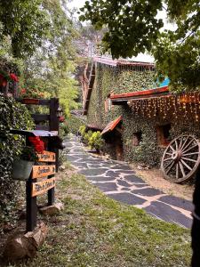 un camino de piedra junto a un edificio con flores en La Posada Cercedilla, en Cercedilla