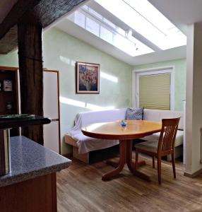 a living room with a table and a bed at FeWo Zum Schwarzen Adler in Niederdorla