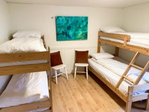 een kamer met 2 stapelbedden en 2 stoelen bij Drømmebrygga in Averoy +72 foto's