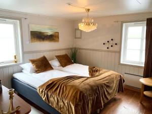 a bedroom with a bed with white sheets and a chandelier at Drømmebrygga in Averoy