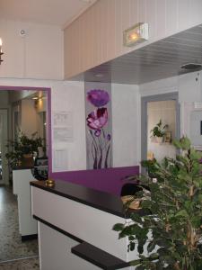 eine Theke mit einem Bild von Blumen an der Wand in der Unterkunft Europa Hotel in Roussillon en Isere