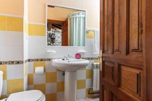 Un baño con lavabo, inodoro y espejo. en Casa El Campano, en Ontaneda 59 fotos más