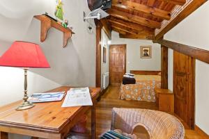 Habitación con escritorio con lámpara y dormitorio. en Casa El Campano, en Ontaneda