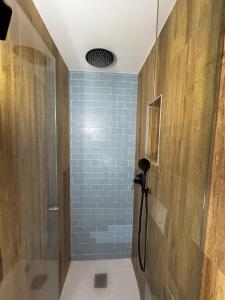 een badkamer met een douche en een blauwe tegelmuur bij Mazuelo - Harbor's Light in Villajoyosa