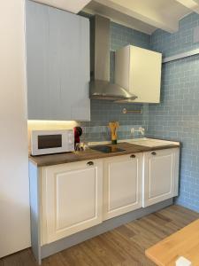 een keuken met witte kasten en een magnetron bij Mazuelo - Harbor's Light in Villajoyosa +2 foto's