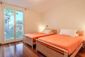 Dos camas en una habitación con ventana. en Villa La Duna, en Marina di Castagneto Carducci