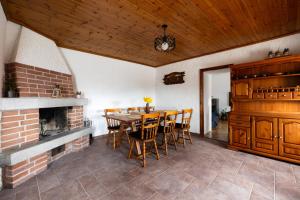 a dining room with a fireplace and a table and chairs at Wellba Holiday Home Otlica in Ajdovščina