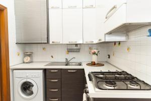 a kitchen with a stove top oven next to a washing machine at Dolce Riviera Marina Centro in Rimini