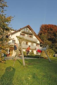 a group of children playing on a swing set in a yard at Baumanns Ferienhof Am See in Bettnau