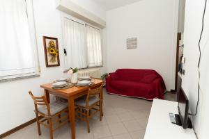 a living room with a table and a red couch at Dolce Riviera Marina Centro in Rimini