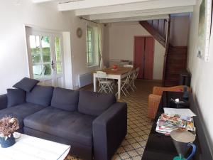 ein Wohnzimmer mit einem blauen Sofa und einem Tisch in der Unterkunft Lovely house with grass garden, shared swimmingpool, next to the river Ardèche in Lalevade-dʼArdèche