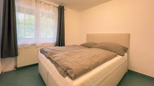 a small bed in a room with a window at Gemütliches Apartment in Velden in Velden am Wörthersee