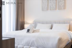 سرير أو أسرّة في غرفة في Stylish 1BR in Peninsula Five Views & Pool
