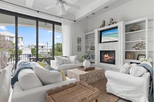 a living room with white furniture and a fireplace at 15 Mathis Cove in Inlet Beach