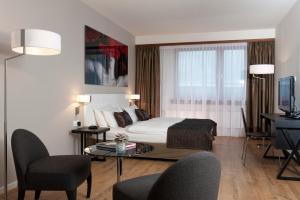 a hotel room with a bed and a table and chairs at Wyndham Stuttgart Airport Messe in Stuttgart