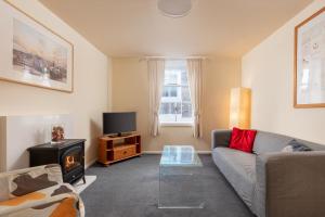 a living room with a couch and a tv at Discovery Accommodation in Whitby
