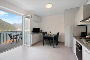 a kitchen and dining room with a table and a balcony at Appartamento 6 Il Tornante in Nesso