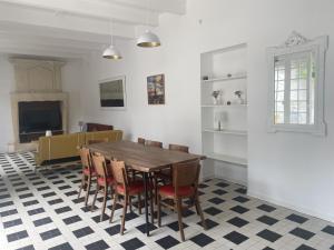 a dining room with a table and chairs on a checkered floor at Location maison l'embellie in La Tremblade