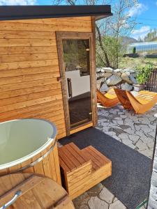 a bath tub sitting next to a wooden house at Chata do Zlatneho in Terchová