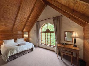 a bedroom with a large bed and a window at Millstream Farm Cottages in Dullstroom
