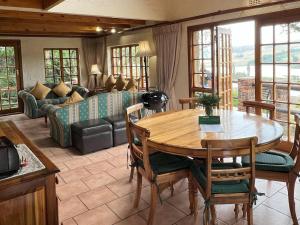 a living room with a table and a couch at Millstream Farm Cottages in Dullstroom