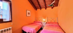 two beds in a room with orange walls at Casa Vacacional El Alberu in La Borbolla