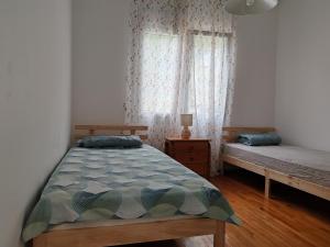 a bedroom with a bed and two windows with curtains at Rose House in Kavála