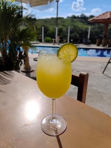 a drink sitting on a table with a slice of lime at Pousada irmãos Oliveira in Lindóia
