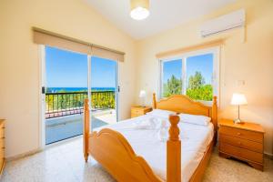 a bedroom with a bed and a large window at Villa Aristotelis in Argaka +25 photos