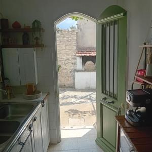a kitchen with an open door to a courtyard at En Sylikion cottage in Silikou +39 photos