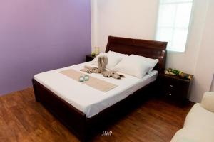 a bedroom with a bed with towels on it at Villa Kathreyna Private Resort in Alianza