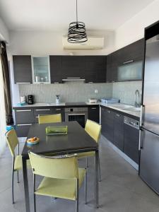 a kitchen with a black table and yellow chairs at Irene Appartment in Katakolo